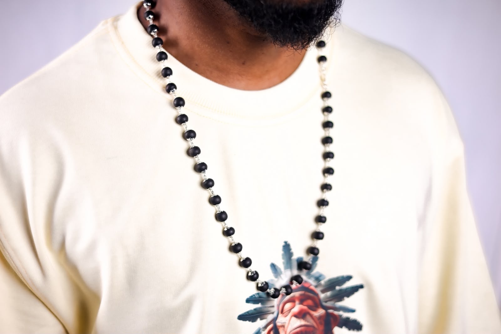Obsidian bead rosary worn over cream tee